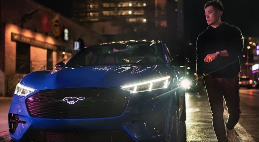 Ford%20EVs%20-%202024%20Ford%20Mustang%20Mach-E%20GT%20SUV%20-%20Blue.jpg A man walking away from a parked blue 2024 Ford Mustang Mach-E.
