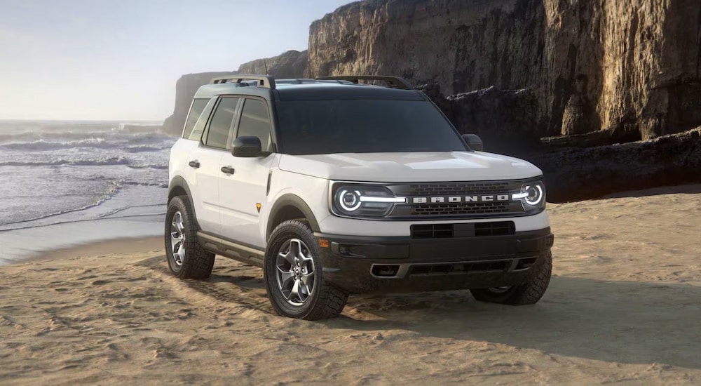 A white 2024 Ford Bronco Sport Badlands for sale parked on a sandy beach.