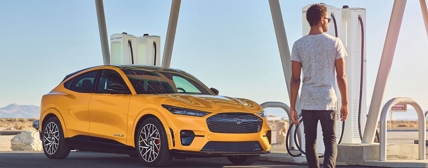 A yellow 2021 Ford Mustang Mach-E GT is shown from the front at an angle.