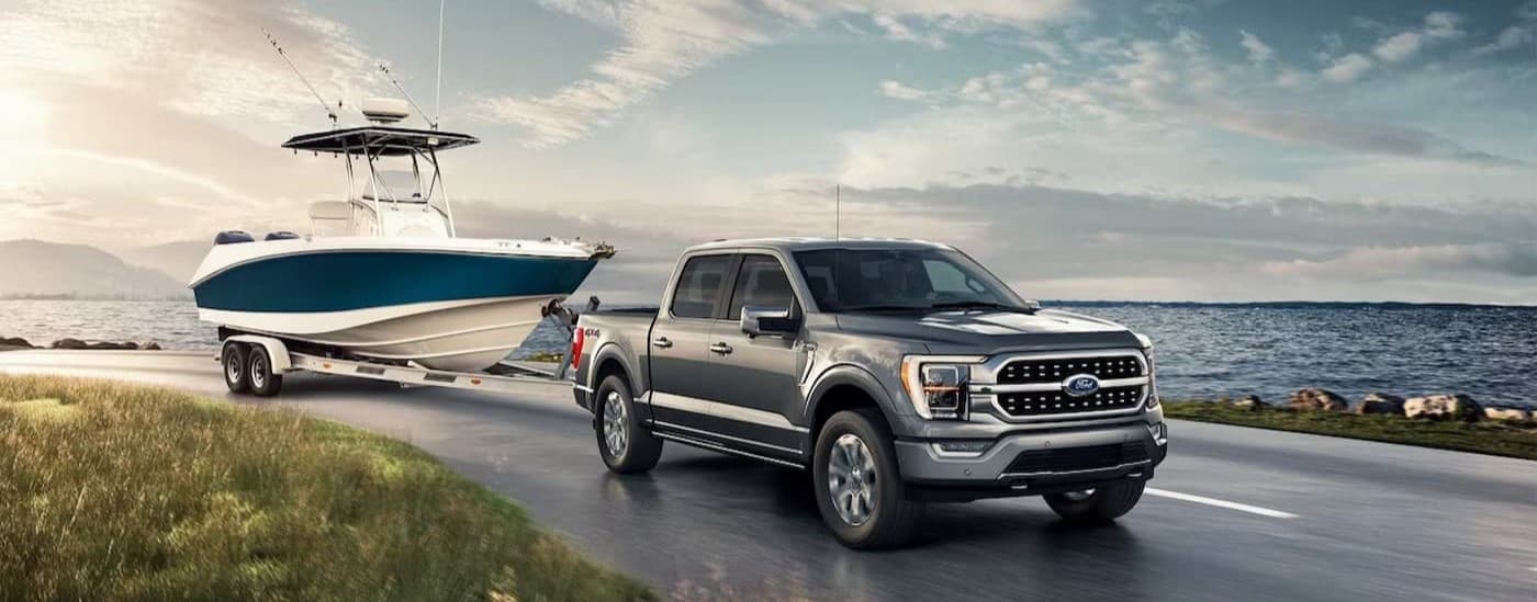 A gray 2023 Ford F-150 towing a boat.