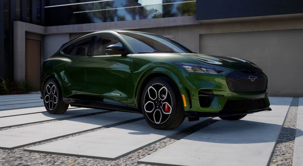 A green 2024 Ford Mustang Mach-E GT parked on a driveway of pavers.