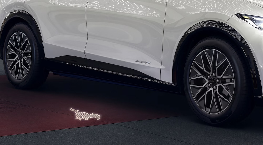 The pony logo puddle lamp coming from a white 2024 Ford Mustang Mach-E.