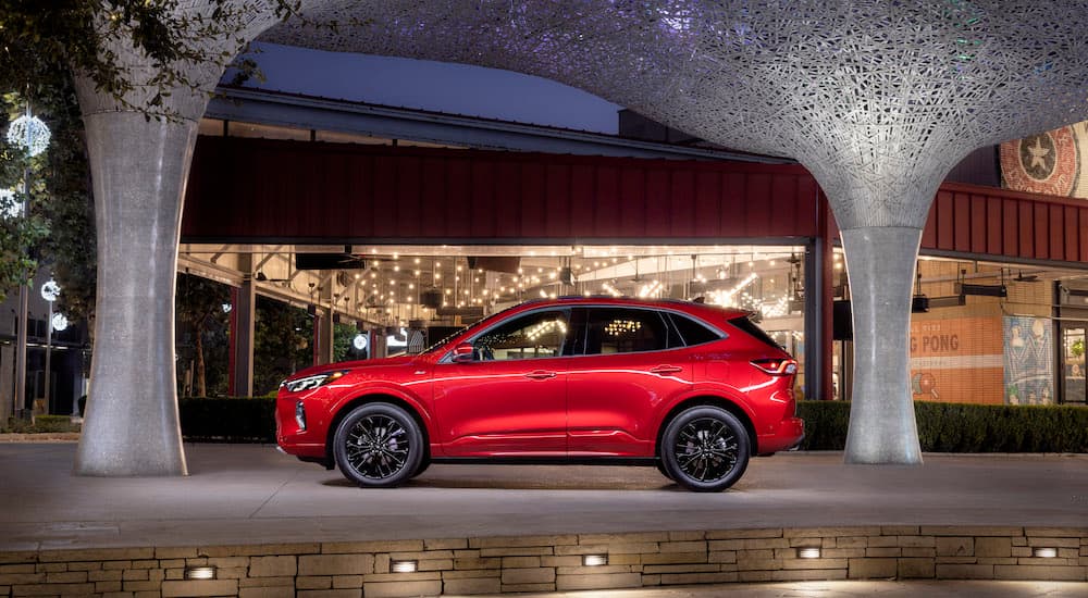A red 2024 Ford Escape ST-Line is shown from the side.