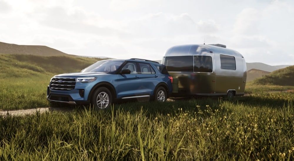 A blue 2025 Ford Explorer for sale near Jackson towing a trailer.