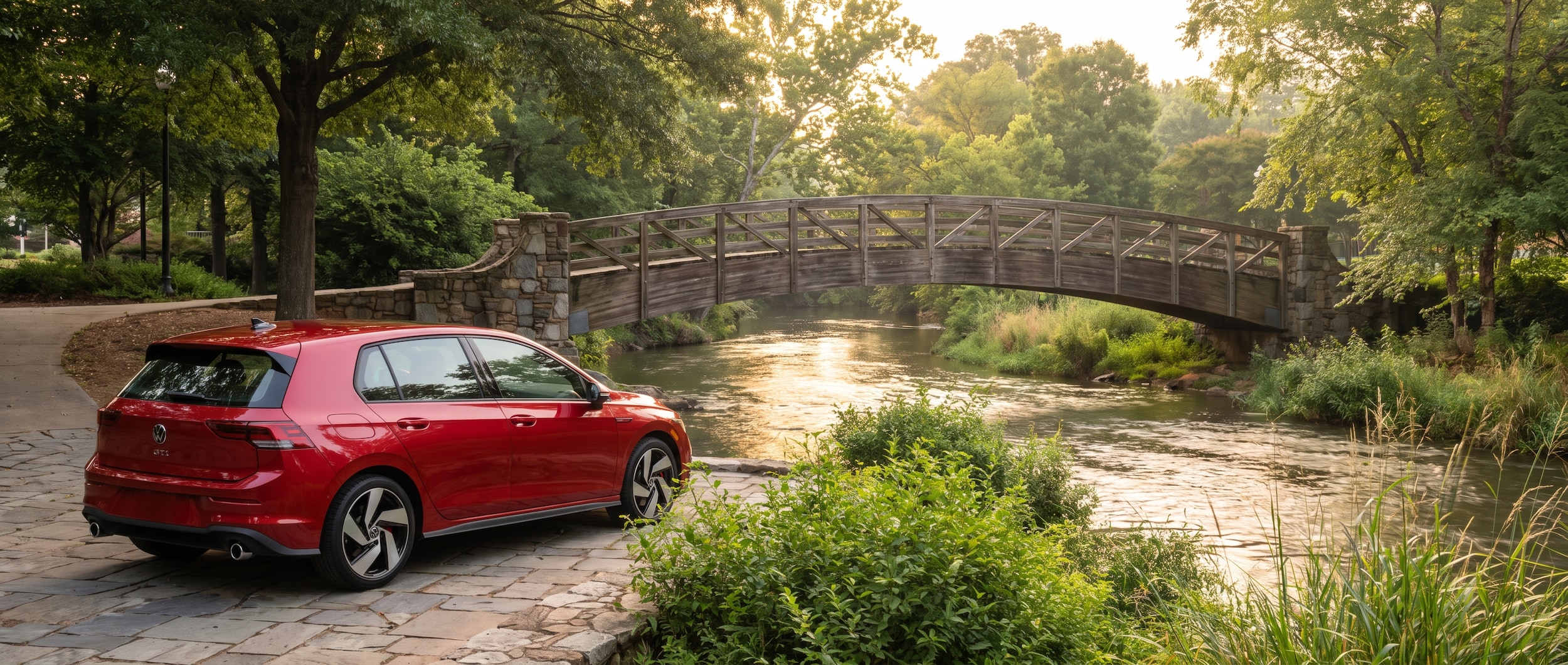 2026 Volkswagen Golf GTI parked near a river pedestrian bridge in Downtown Greenville SC at early morning with soft dawn light