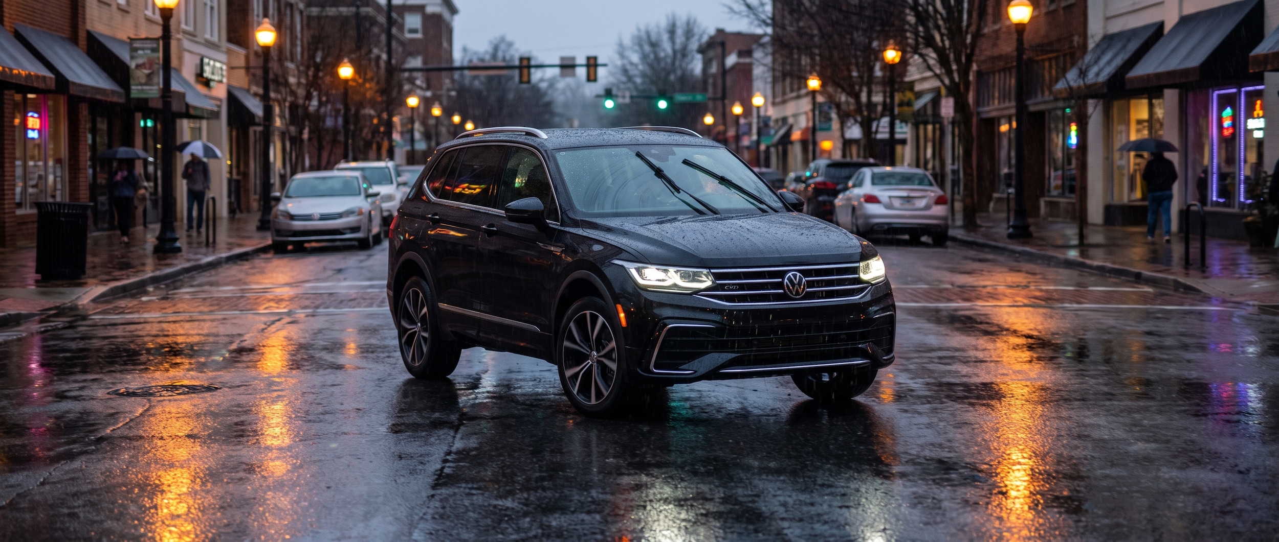 2026 Volkswagen Tiguan driving on a rain-slicked Greenville SC street with IQ.DRIVE safety systems active at dusk