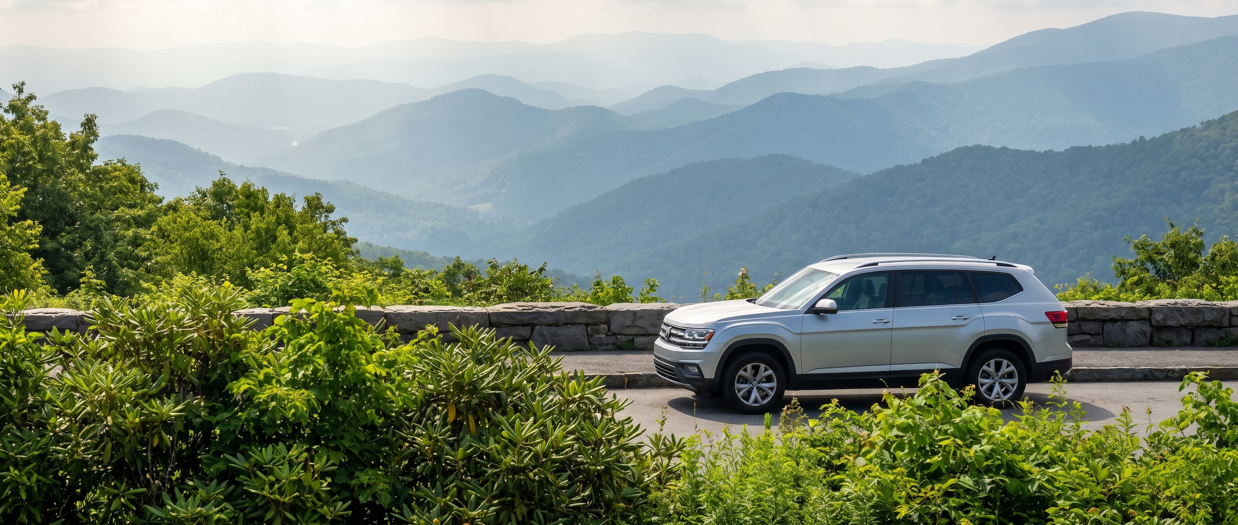 Volkswagen SUV at Blue Ridge Parkway overlook near Asheville NC with mountain ridgelines in summer