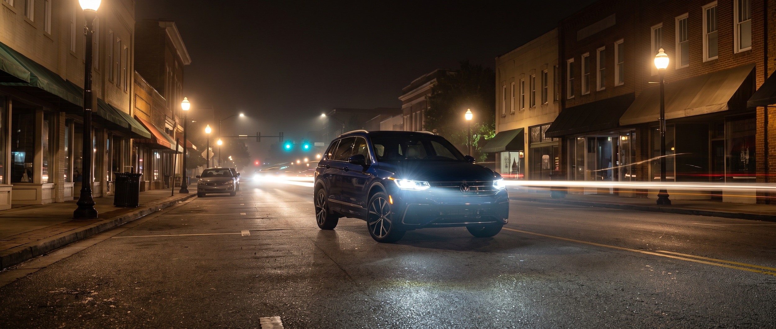 2026 Volkswagen Tiguan at night on Laurens Road in Greenville SC with LED headlights on