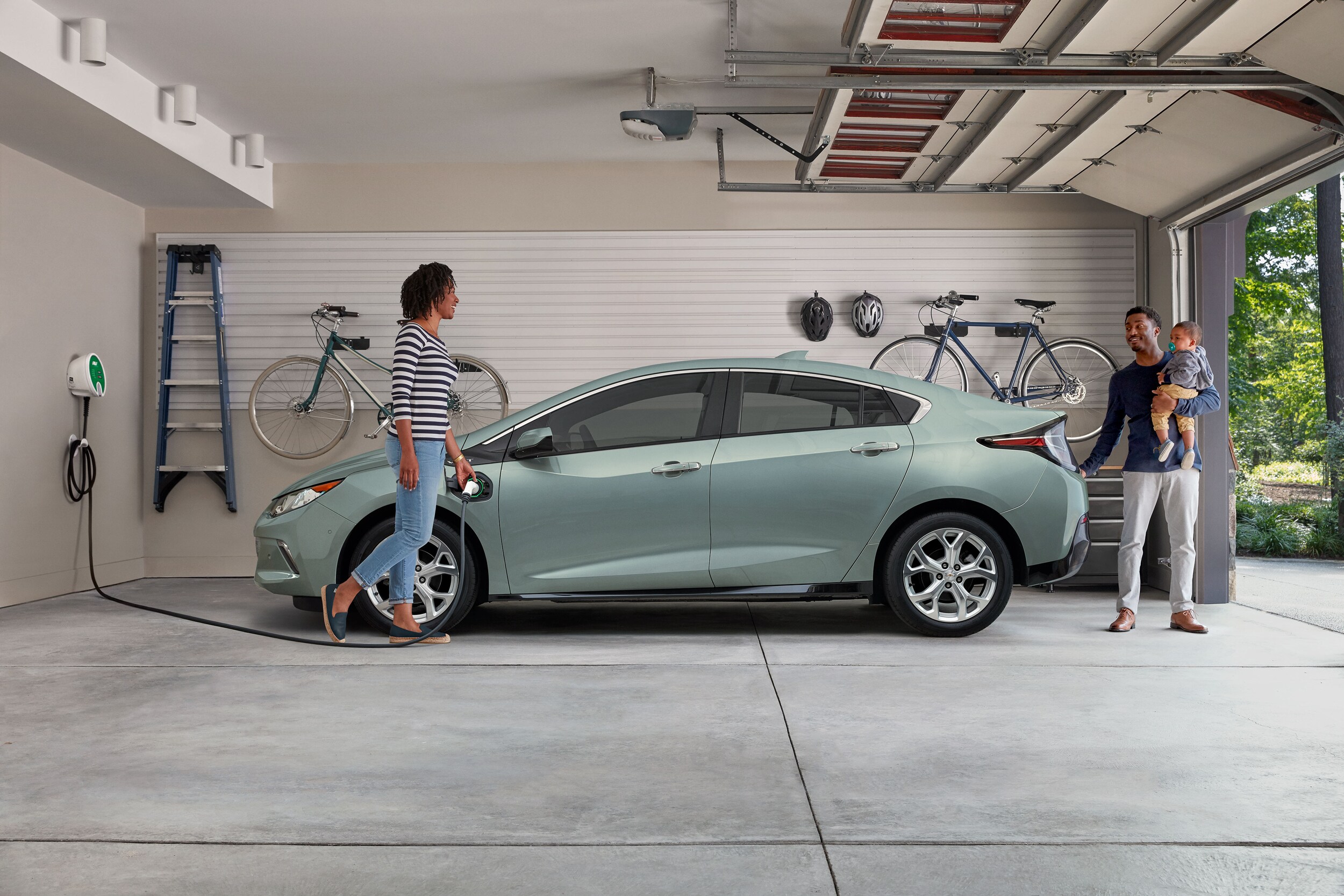 Family having fun with 2 children and electric vehicle in the background
