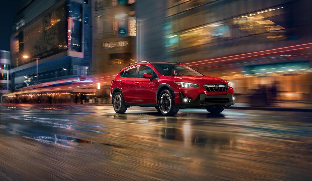 front side view of a 2023 Subaru Crosstrek at night on a boulevard in town