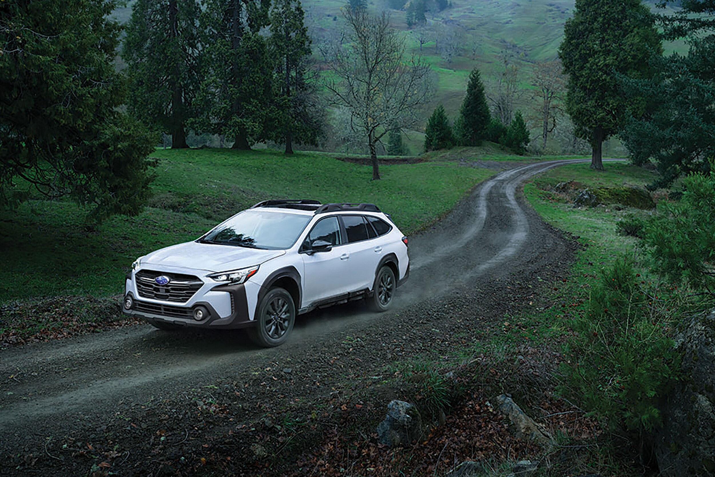 Subaru Outback driving on dirt road