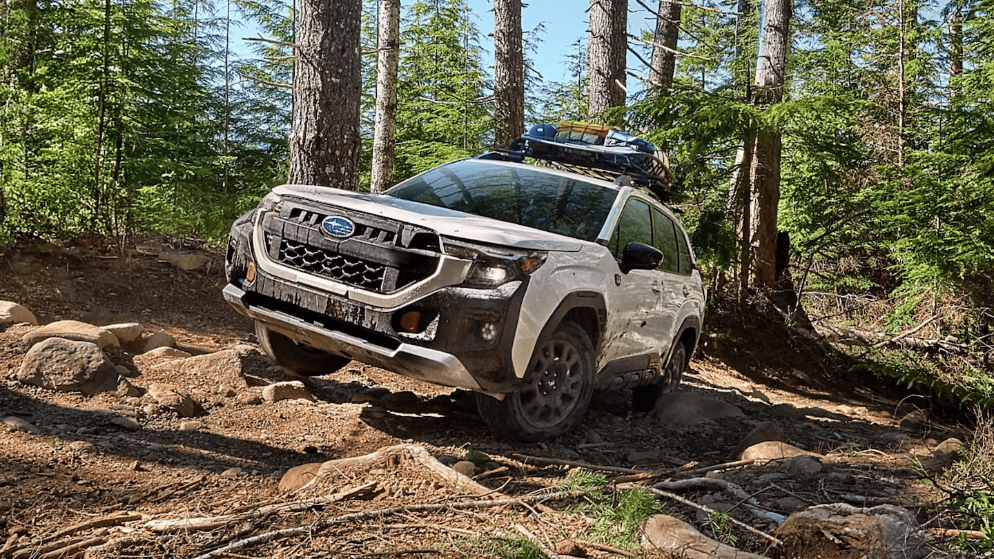 2026 Subaru Outback Wilderness in blue navigating a rocky off-road trail with roof rack in a desert canyon landscape, available in Pueblo CO