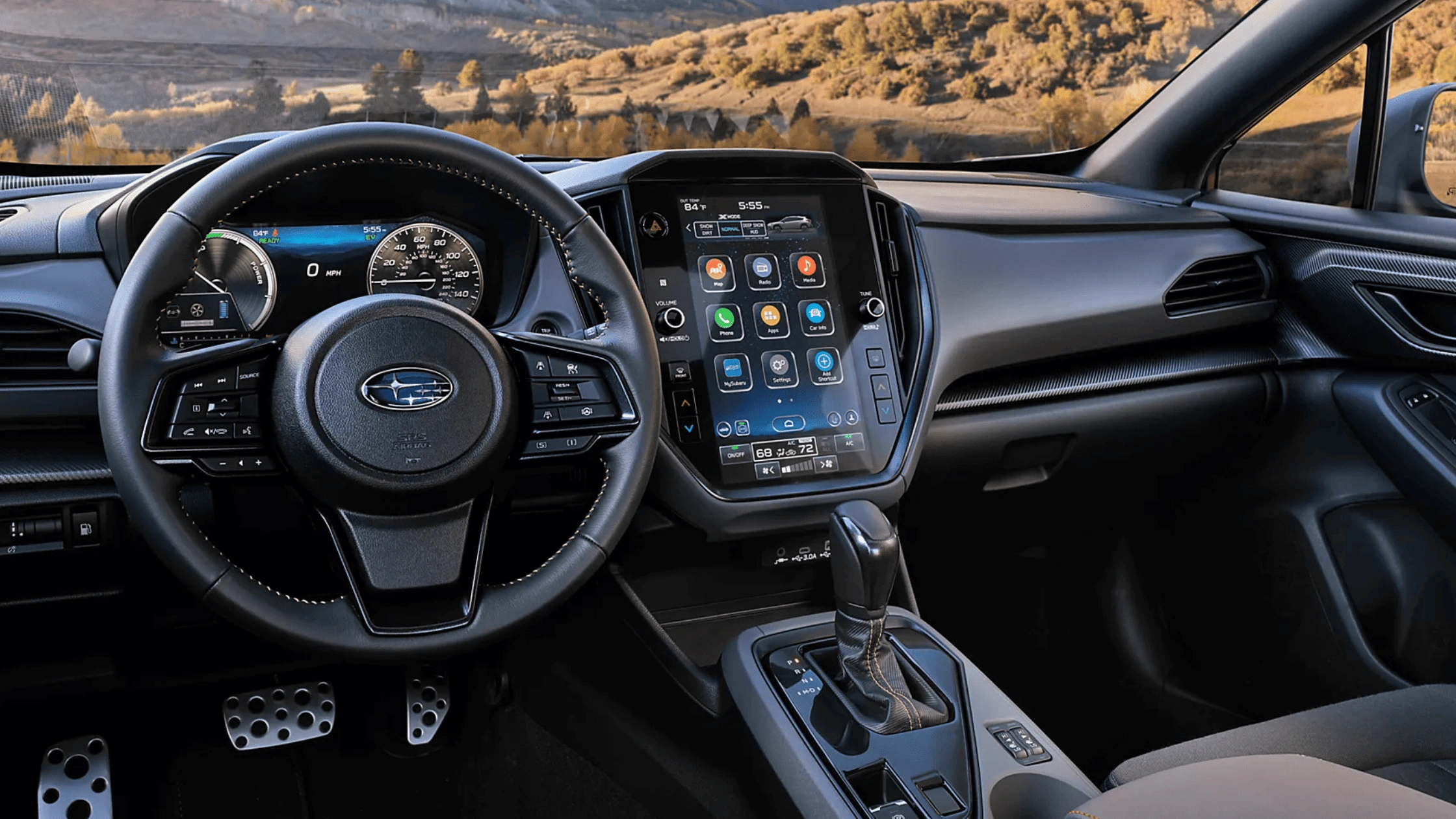 2026 Subaru Outback Wilderness cargo area loaded with camping gear including sleeping bag and trekking poles with rear hatch open in a desert setting