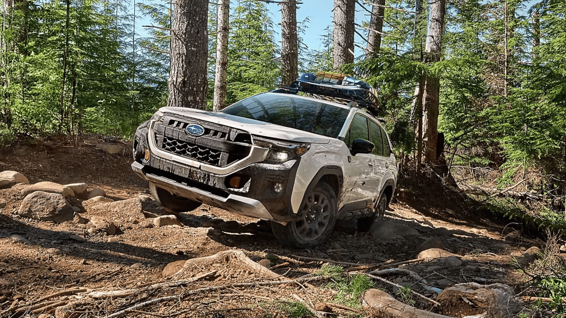 2026 Subaru Outback Wilderness in blue navigating a rocky off-road trail with roof rack in a desert canyon landscape, available in Pueblo CO
