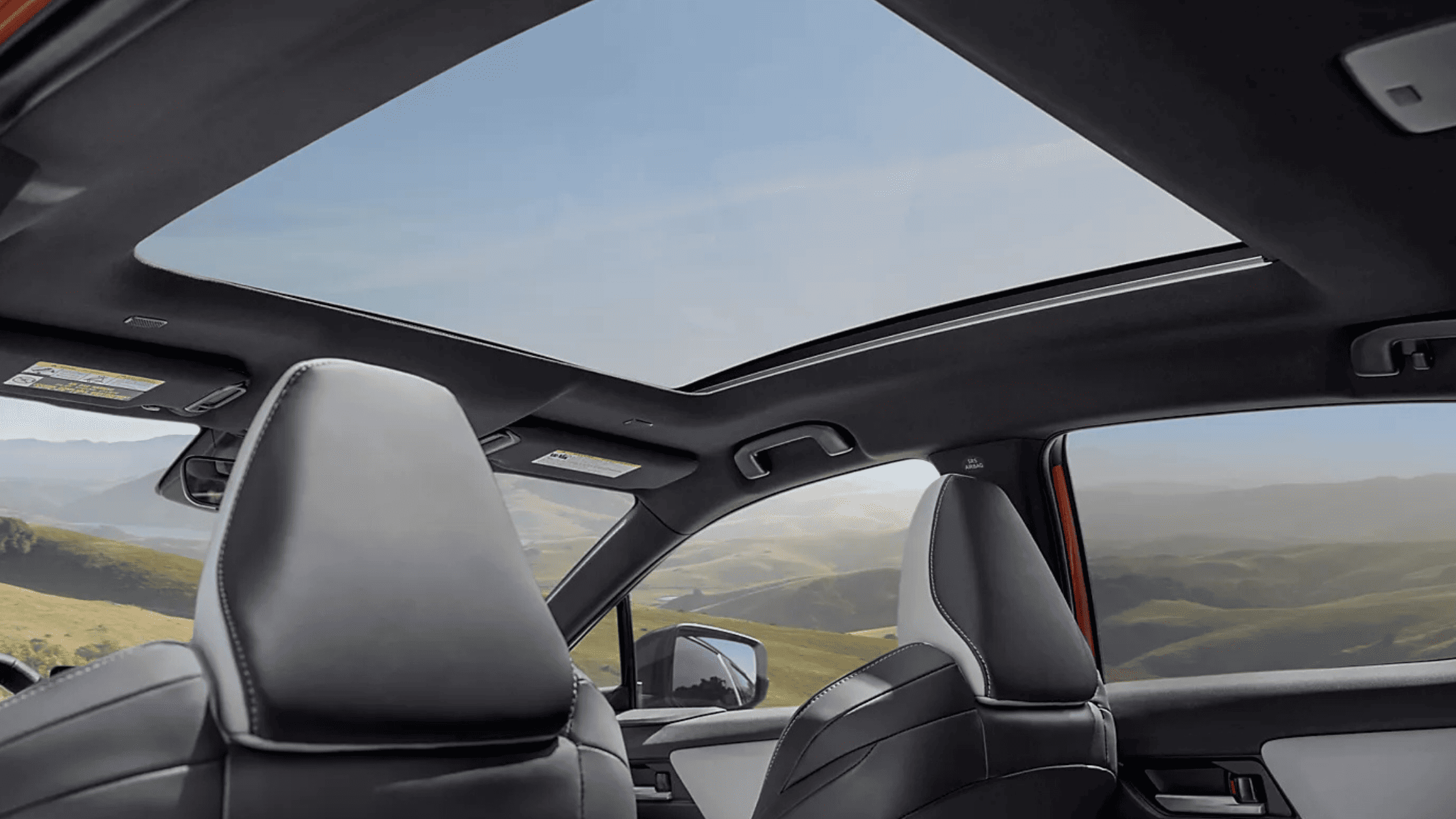 2026 Subaru Outback Wilderness all-black interior showing front and rear leather seats with touchscreen infotainment and mountain view through windows