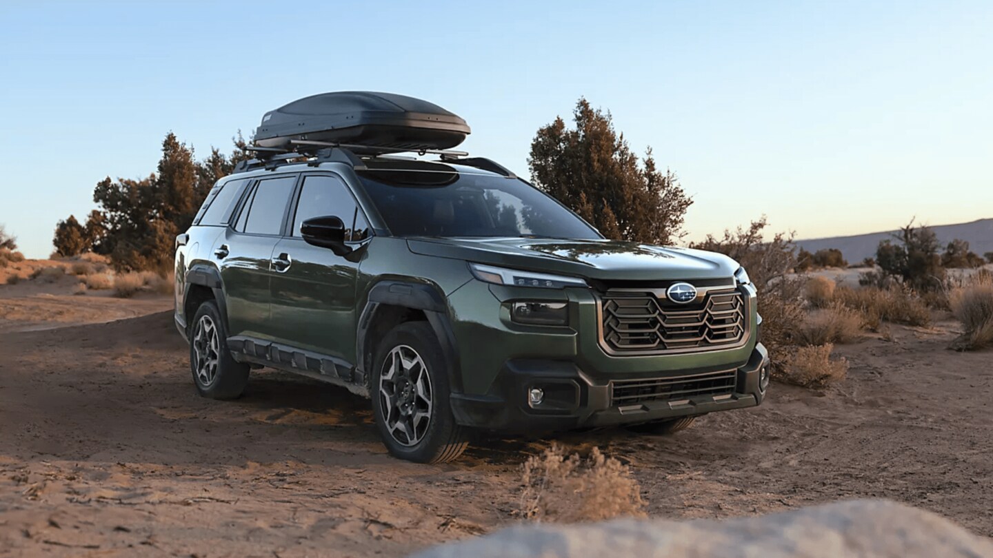 2026 Subaru Outback Wilderness in blue navigating a rocky off-road trail with roof rack in a desert canyon landscape, available in Pueblo CO