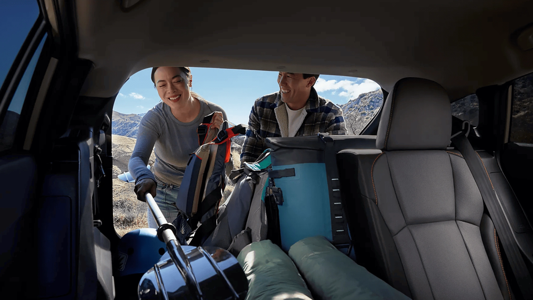 2026 Subaru Outback Wilderness all-black interior showing front and rear leather seats with touchscreen infotainment and mountain view through windows