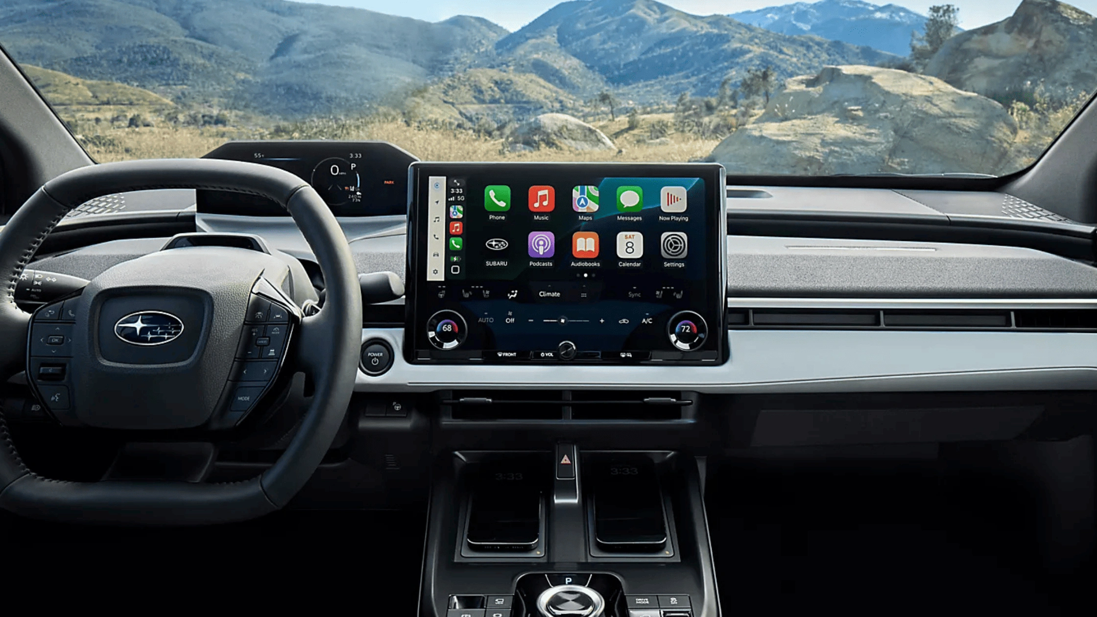 2026 Subaru Solterra interior dashboard with large Apple CarPlay touchscreen, Subaru steering wheel controls, and mountain landscape through windshield