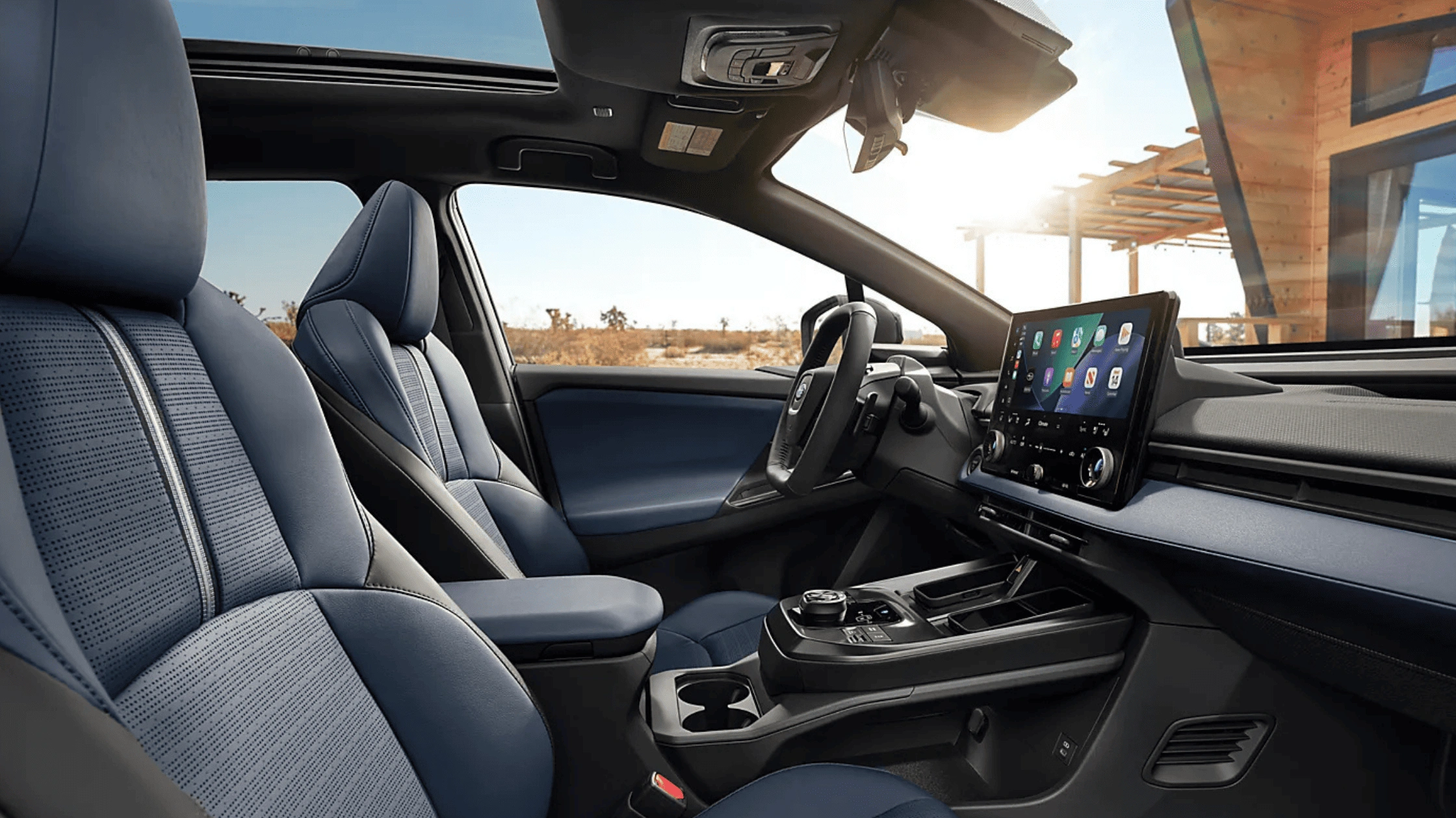 2026 Subaru Trailseeker interior with blue upholstered front seats, large touchscreen infotainment display, and panoramic sunroof