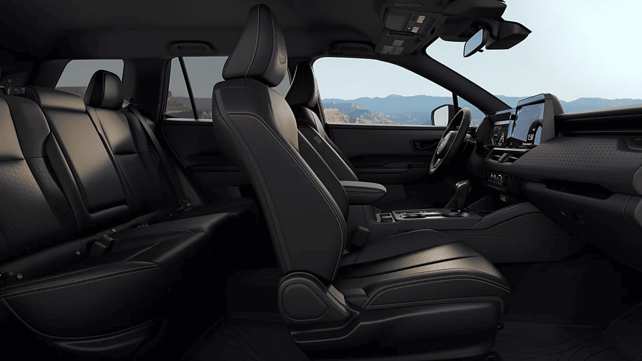 2026 Subaru Outback Wilderness all-black interior showing front and rear leather seats with touchscreen infotainment and mountain view through windows