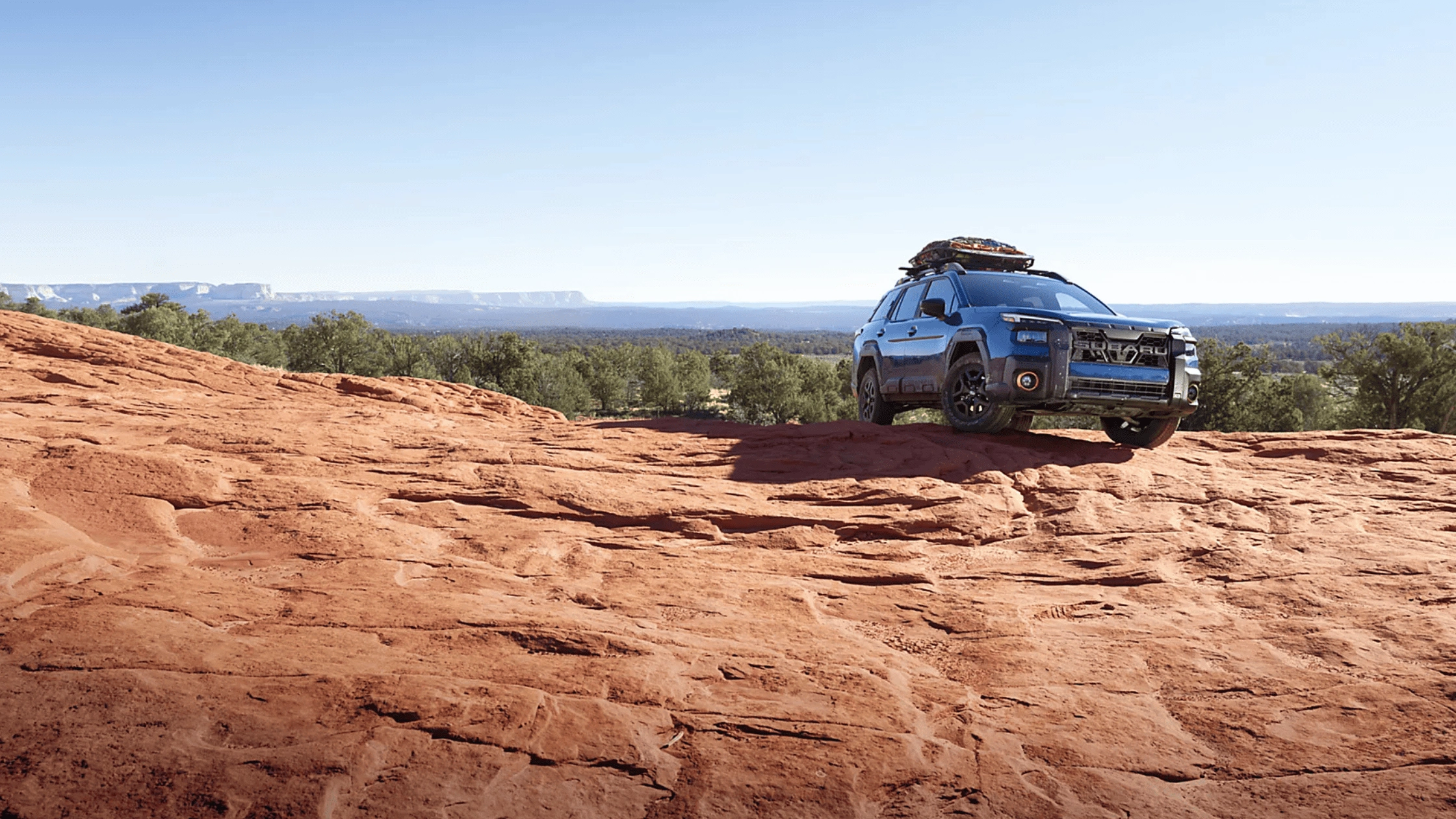 2026 Subaru Outback Wilderness blue SUV parked on red rock desert overlook in Colorado Springs CO