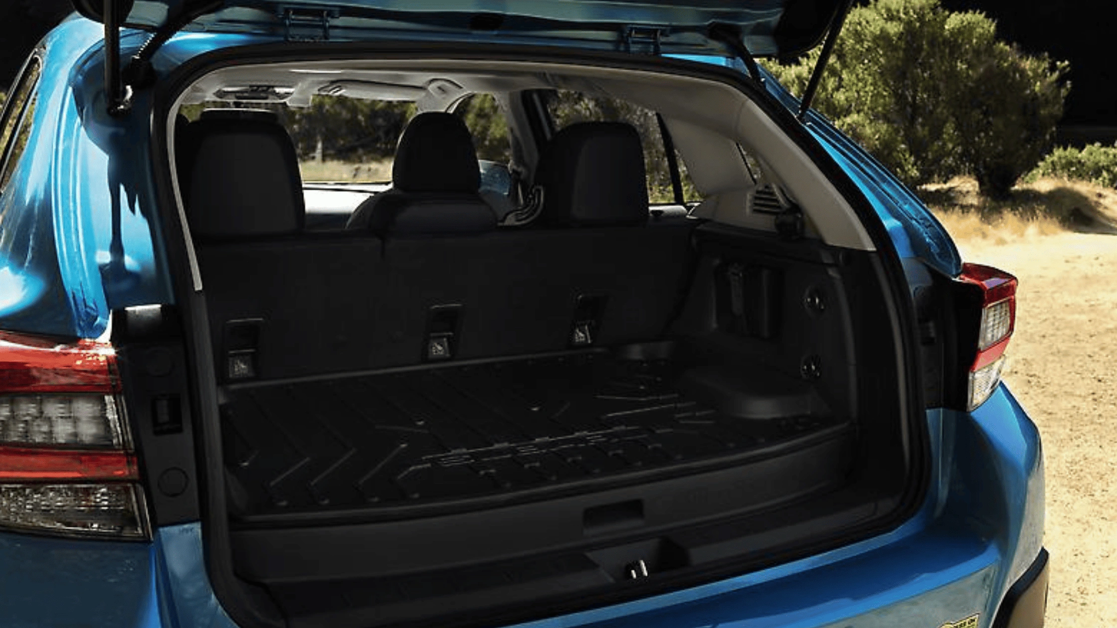 2026 Subaru Crosstrek Hybrid open cargo area with rear seats visible on a dirt trail in Pueblo, CO.