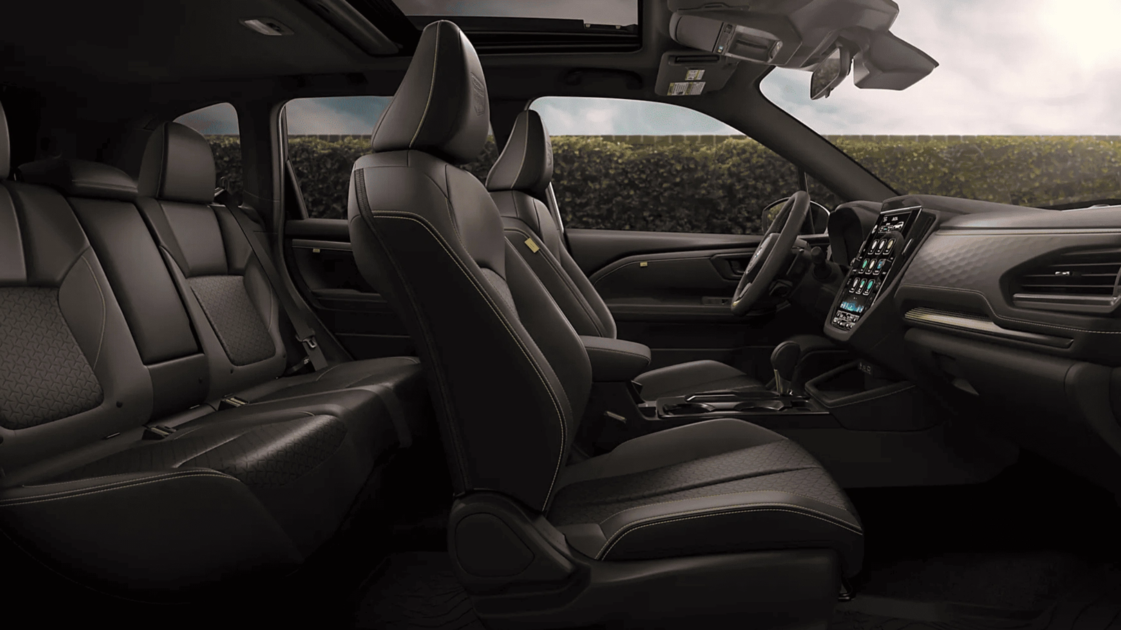 2026 Subaru Outback Wilderness all-black interior showing front and rear leather seats with touchscreen infotainment and mountain view through windows
