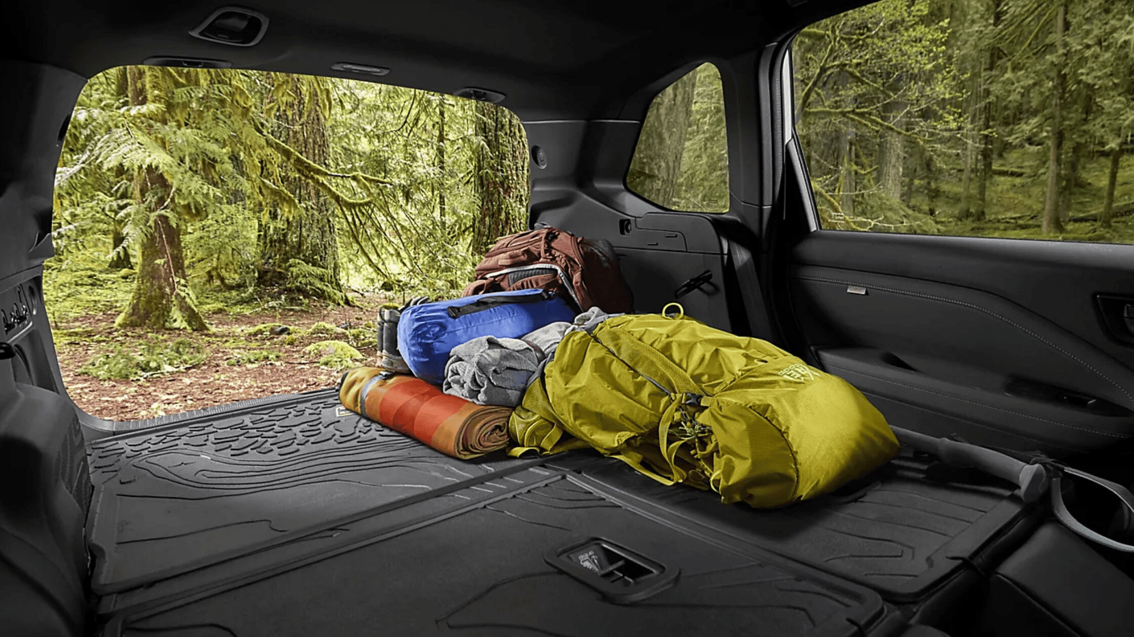 2026 Subaru Outback Wilderness all-black interior showing front and rear leather seats with touchscreen infotainment and mountain view through windows