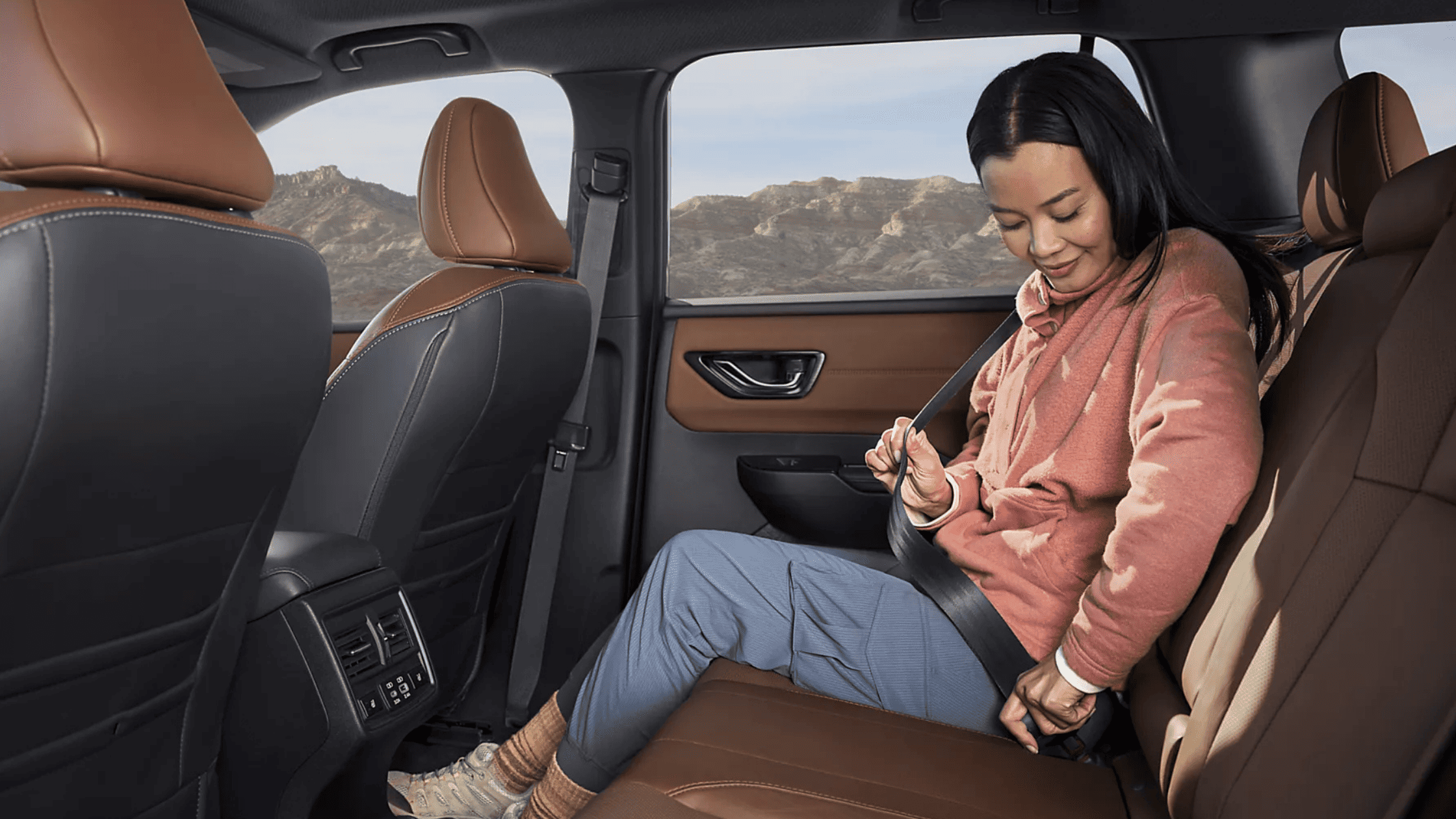2026 Subaru Outback Wilderness cargo area loaded with camping gear including sleeping bag and trekking poles with rear hatch open in a desert setting