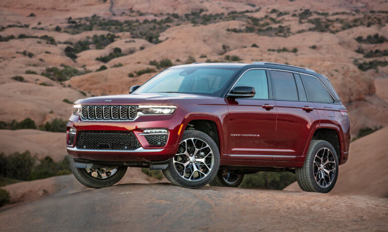 2023 Jeep Grand Cherokee with red exterior on desert rocks