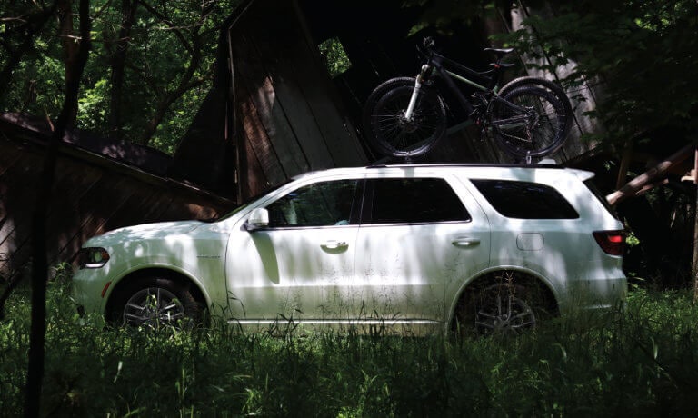 2025 Dodge Durango side view in forest with bikes