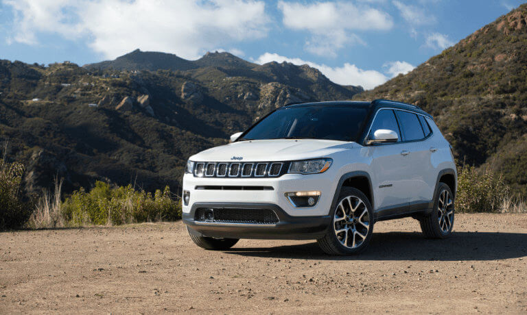 2021 Jeep Compass in by mountain skyline in gravel