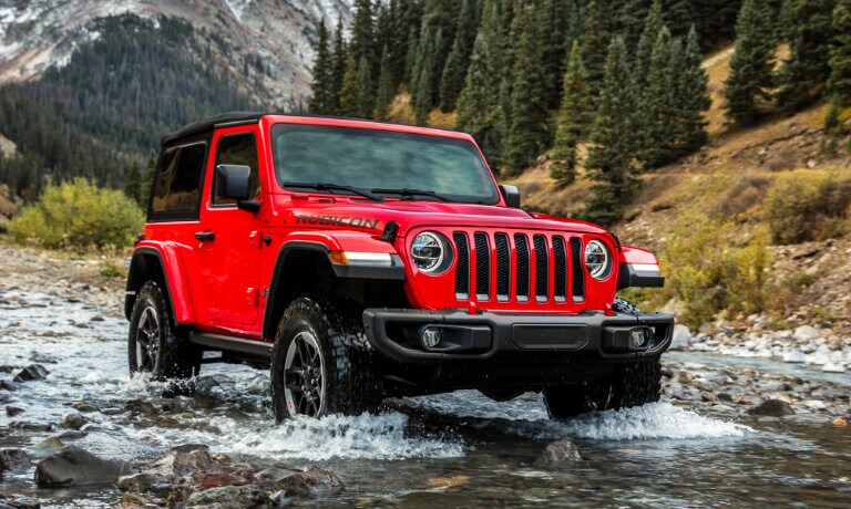 2021 Jeep Wrangler in red exterior driving across waters