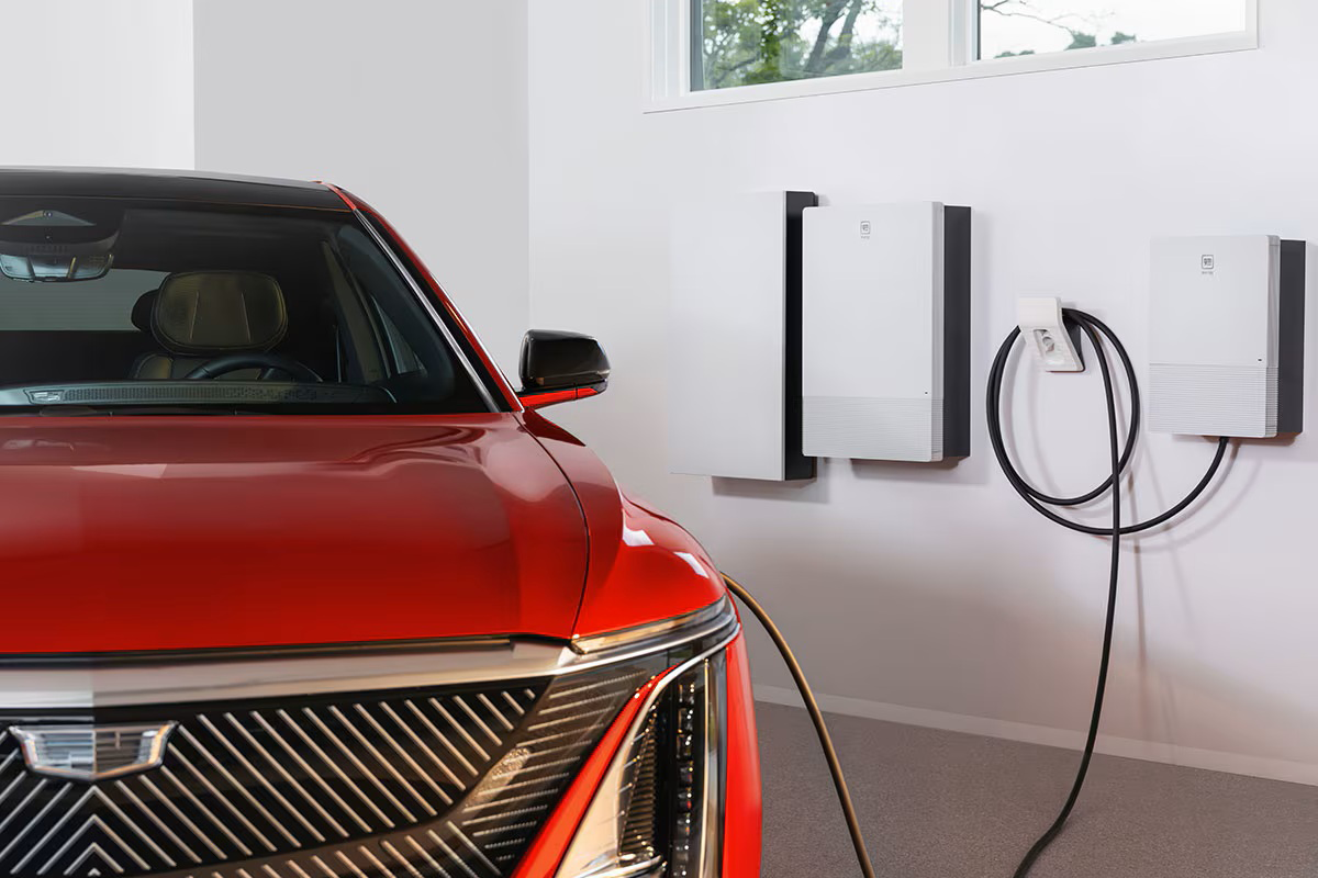  A GM Energy Enablement Kit and PowerShift Charger being used inside a garage with a red Cadillac LYRIQ