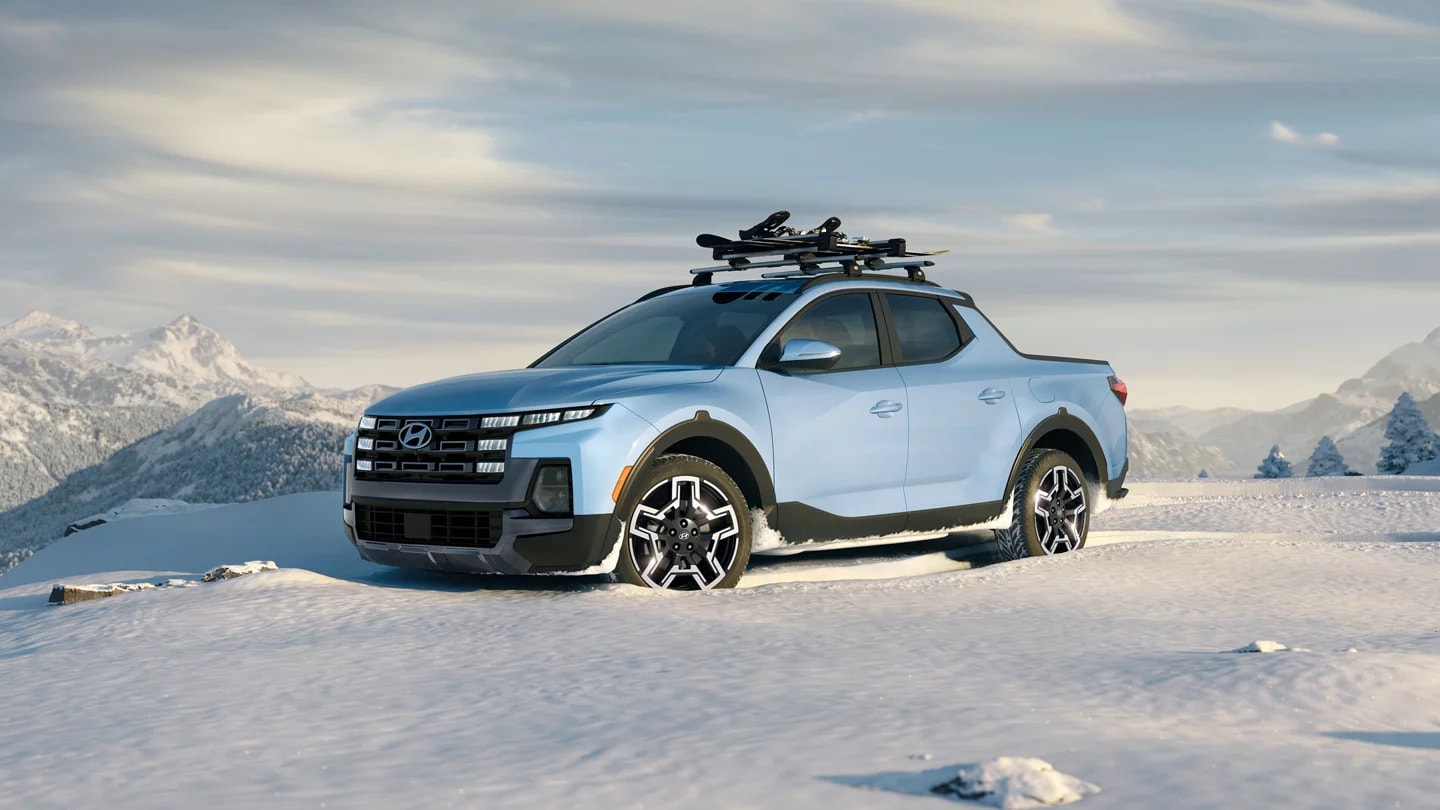 A blue 2025 Hyundai Santa Cruz parked at the top of a snowy mountain