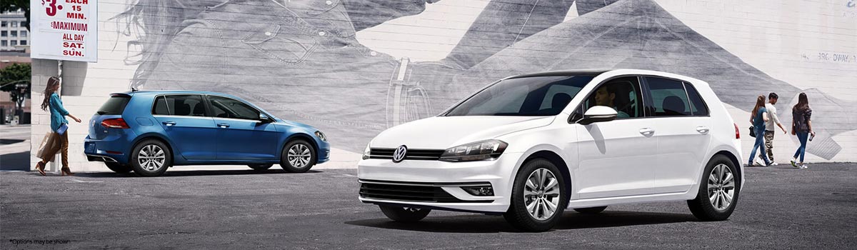 Two 2018 Volkswagen Golfs parked by a brick wall