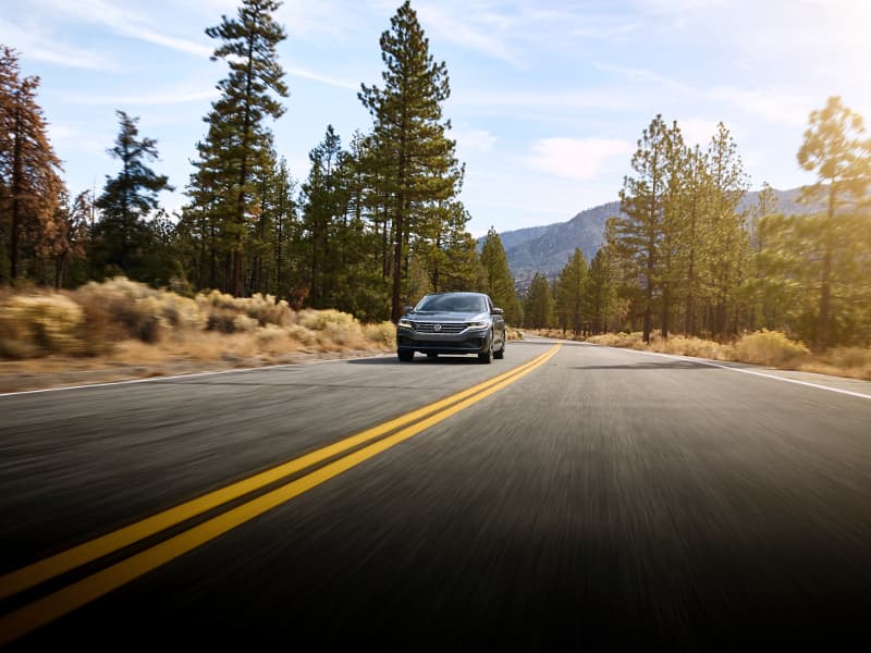 A black 2020 VW Passat driving down an open road