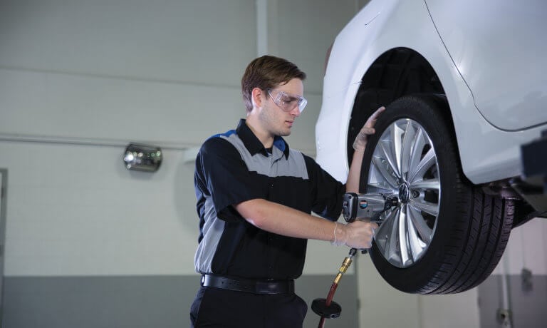 VW service technician working on a tire