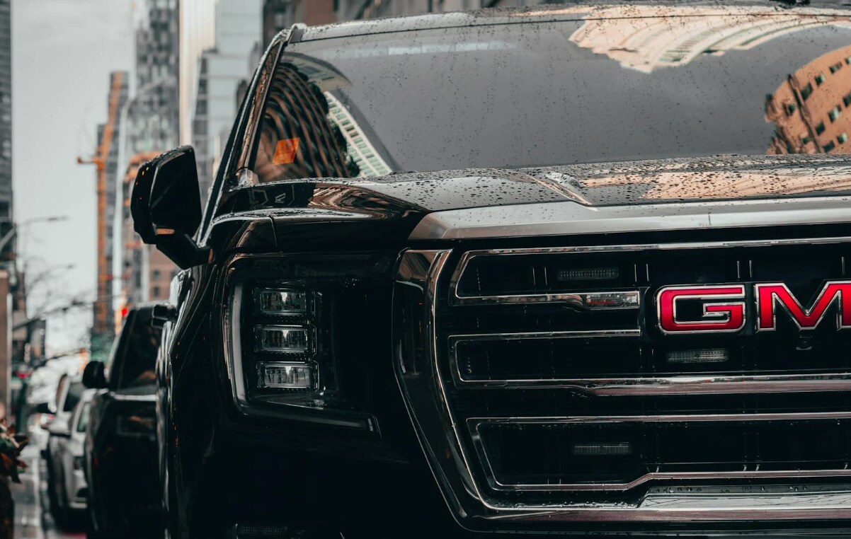 close-up of a gmc grill with town in the background