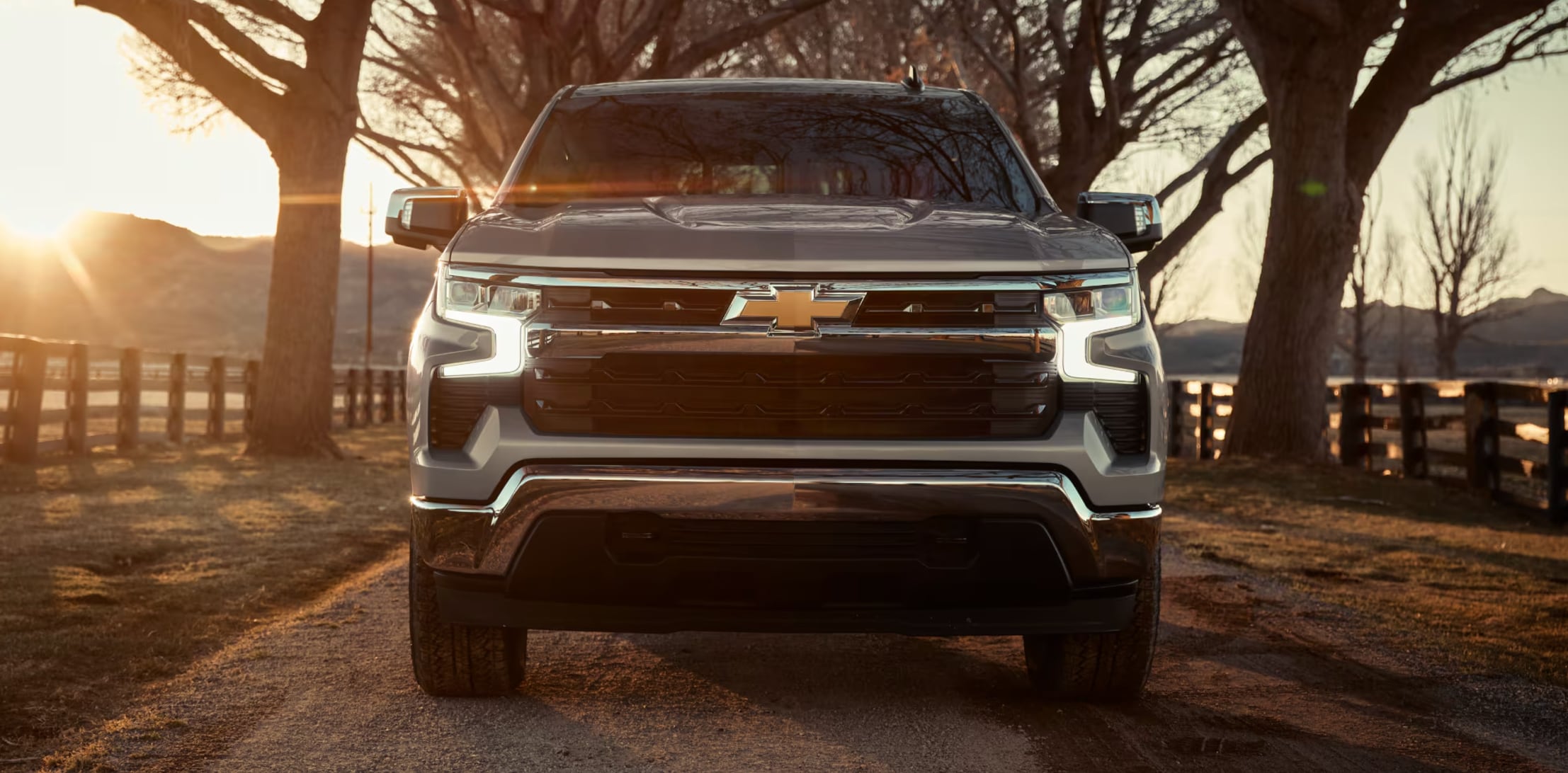 front view of a New Chevrolet Silverado driving at golden hour front view of a New Chevrolet Silverado driving at golden hour