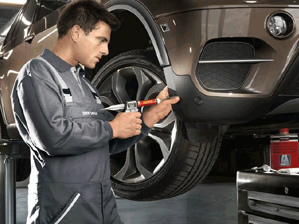 BMW technician repairing bumper on SUV at Thompson BMW in Doylestown, PA