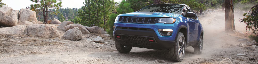 Blue Jeep Compass on top of a mountain