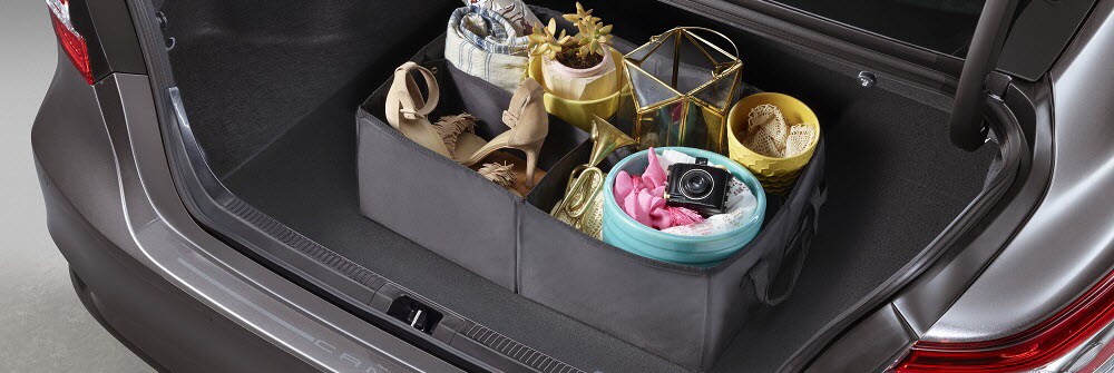 Silver Toyota Camry trunk space with container with 4 sections in it.