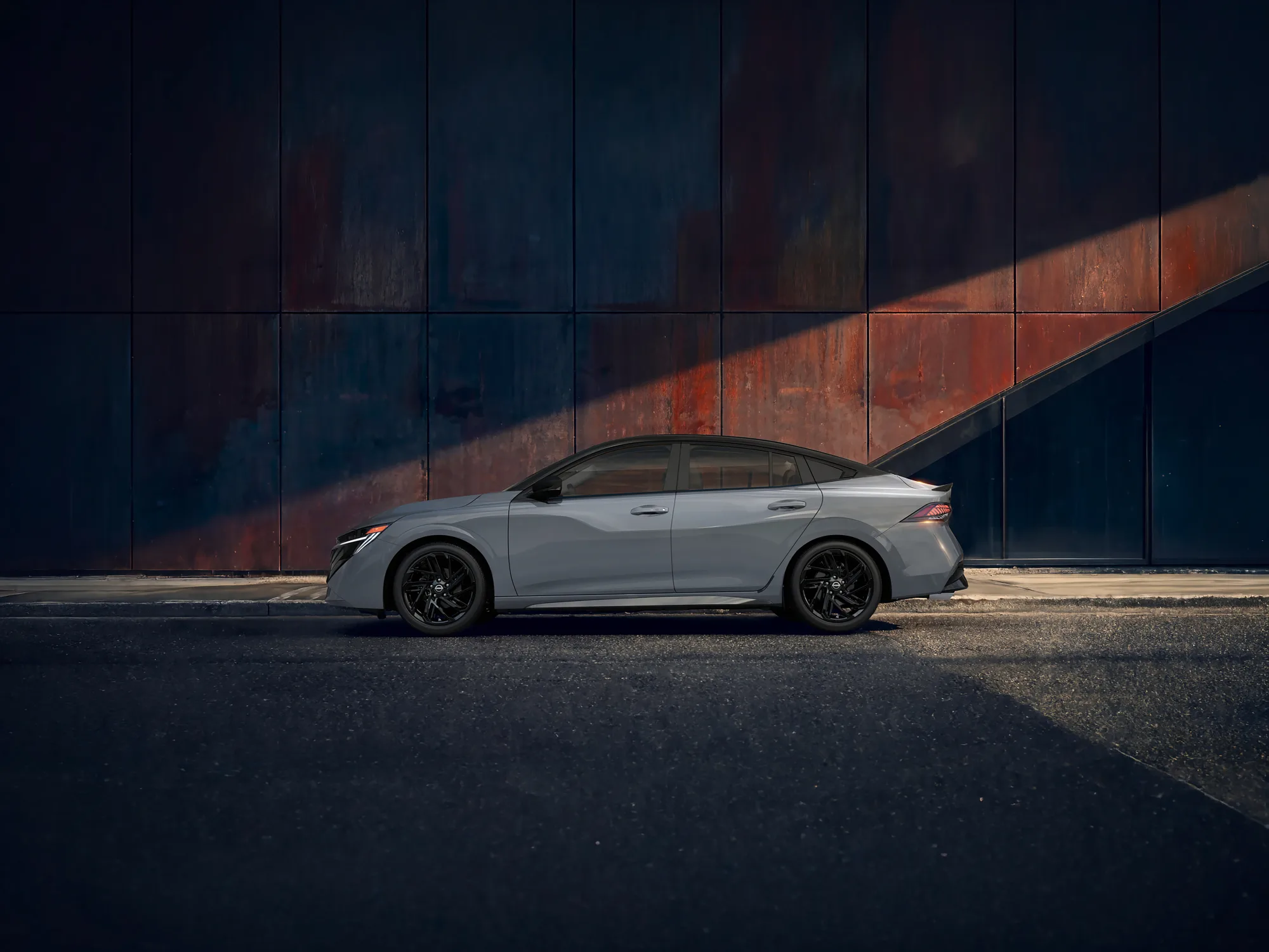 Whit vechicle parked in front of a redish wall. Side view