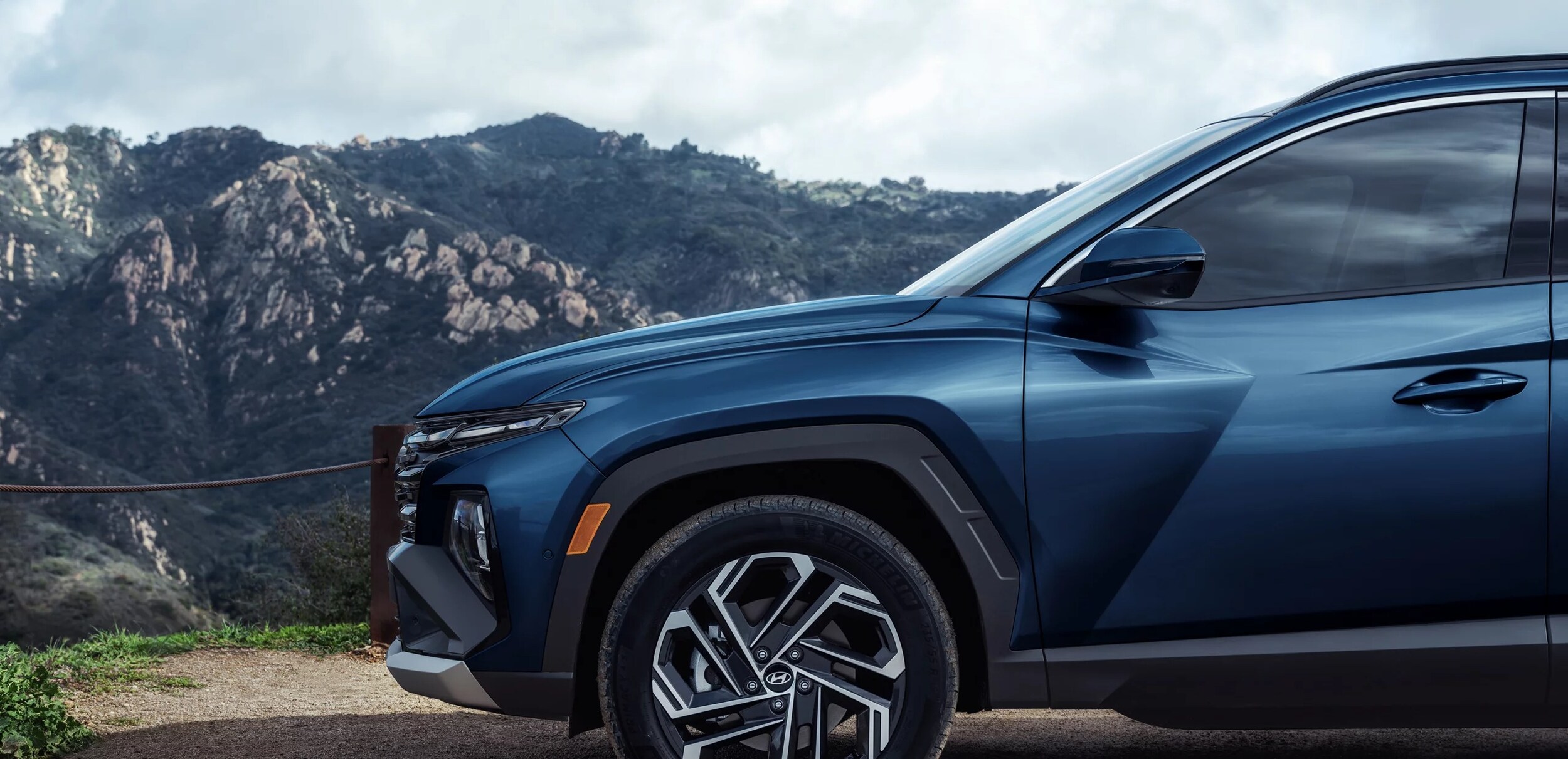 2025 Blue Hyundai Tucson parked on a mountain.