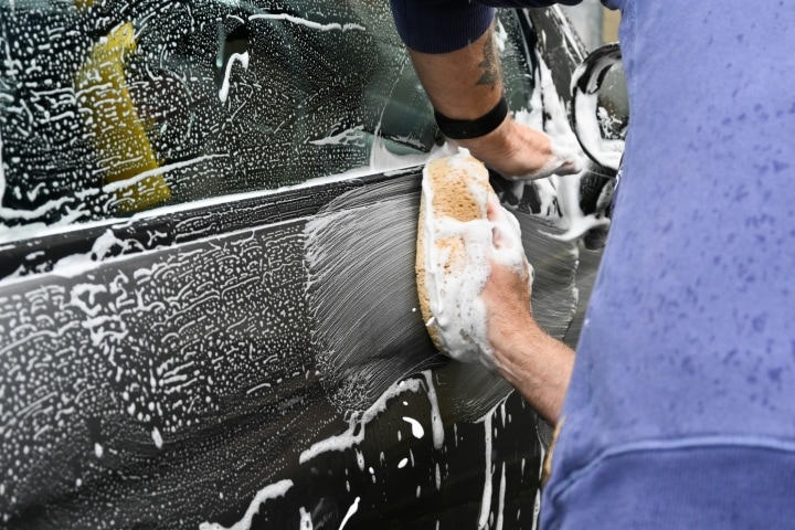 Black Car getting cleaned with a sponge.