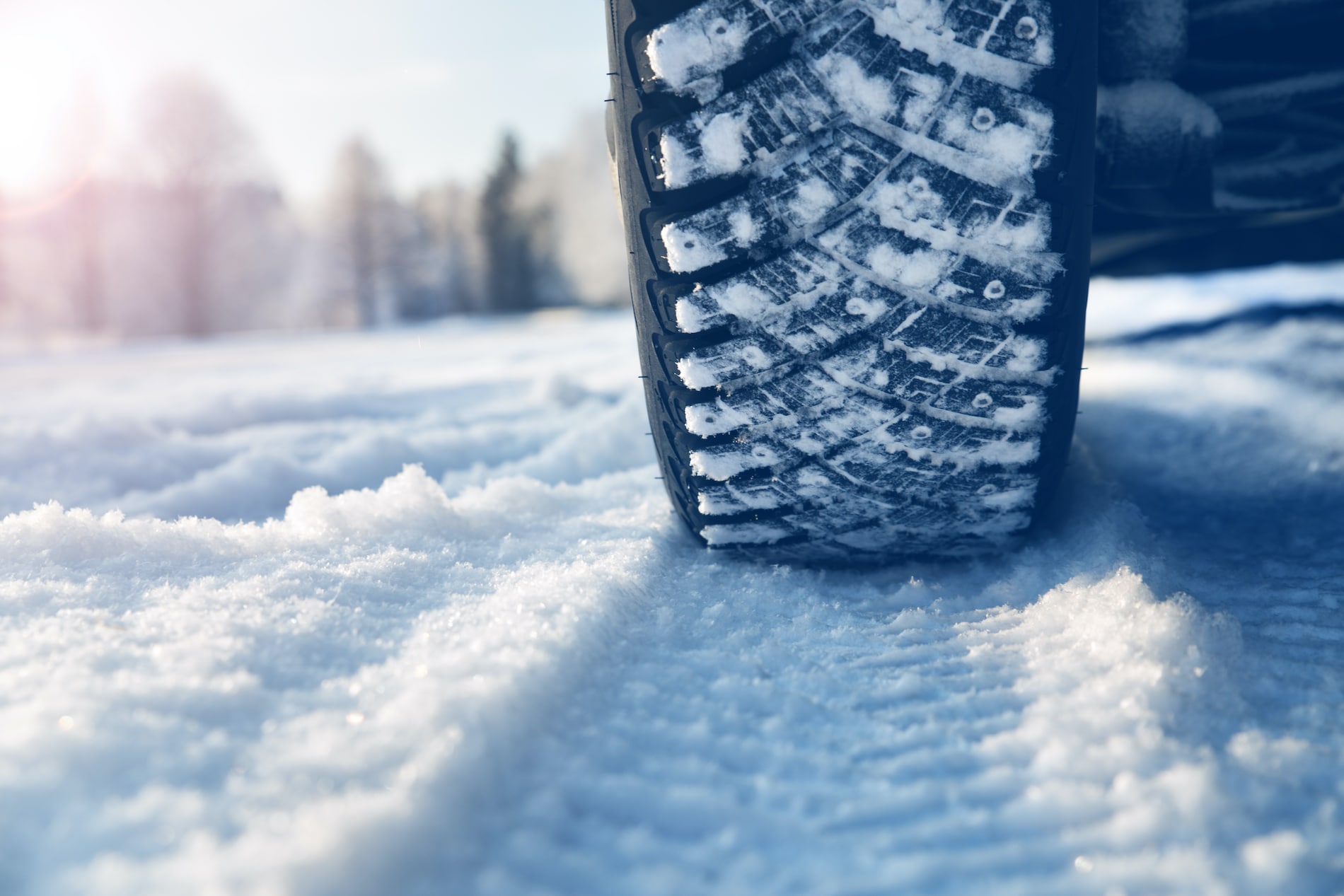 A snowy tire rolling over snow on the ground A snowy tire rolling over snow on the ground