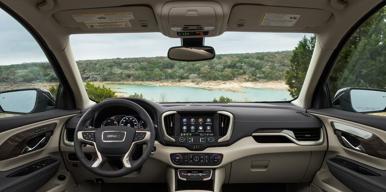 2024 GMC Terrain Denali dashboard with a body of water and trees in view through the windshield