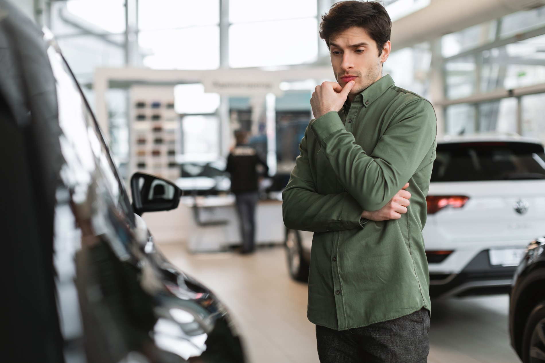 A shopper thinking about a new car at the dealership