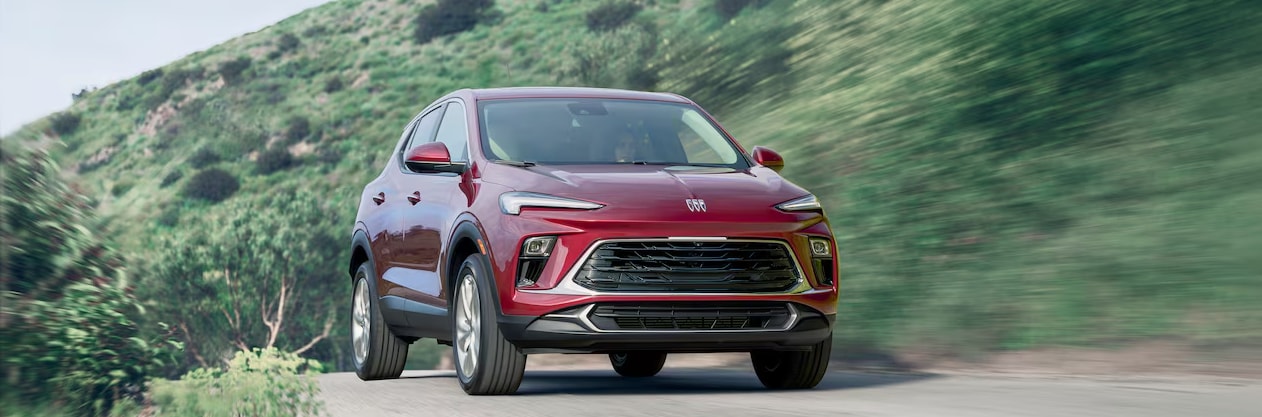 2024 Buick Encore GX driving past a grassy area 2024 Buick Encore GX driving past a grassy area